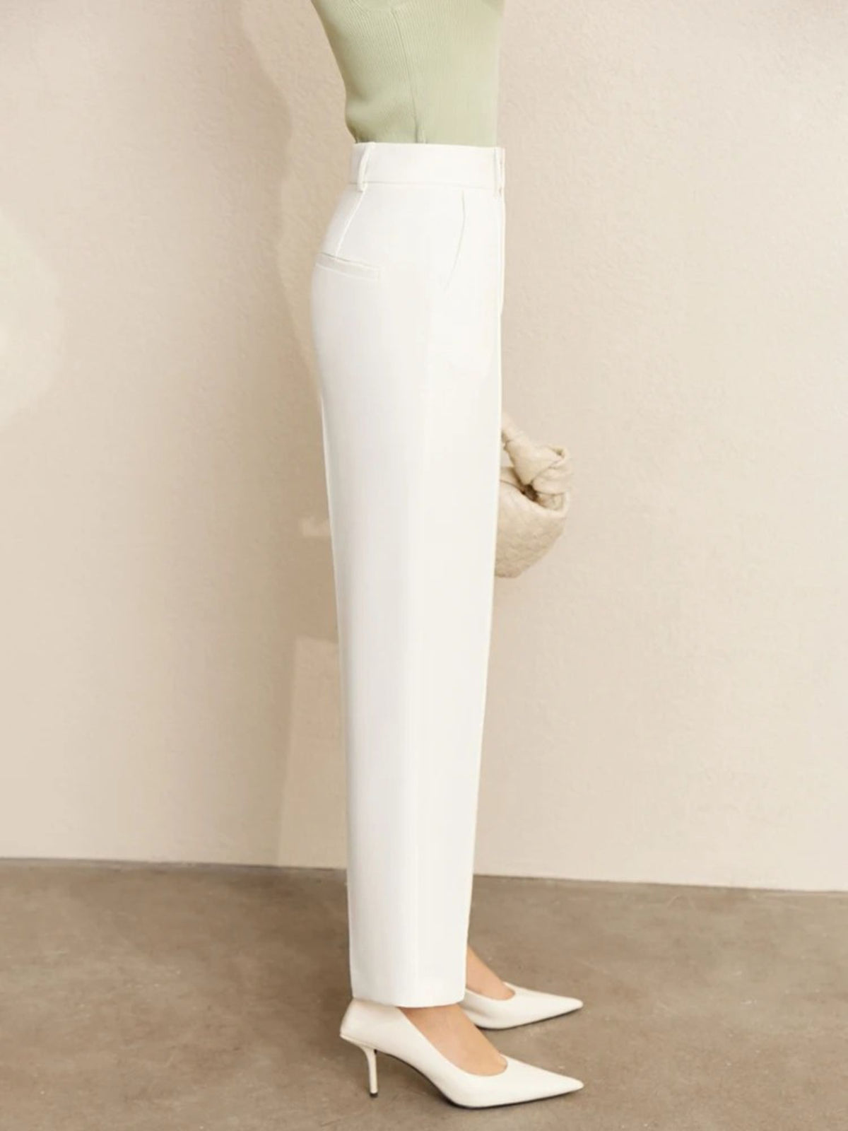 Side view of white trousers with clean hem and pointed heels