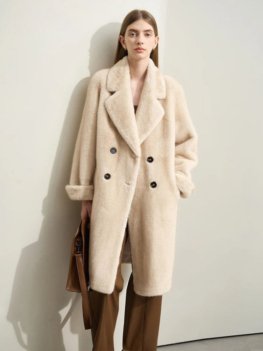A female model wearing a beige faux fur double-breasted winter coat with a turn-down collar and raglan sleeves.