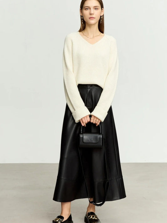 Black satin A-line midi skirt styled with ivory knit sweater and loafers