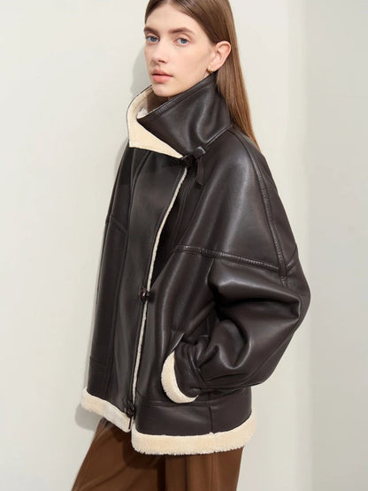 Angled side view of black aviator jacket with shearling trim, worn over brown trousers