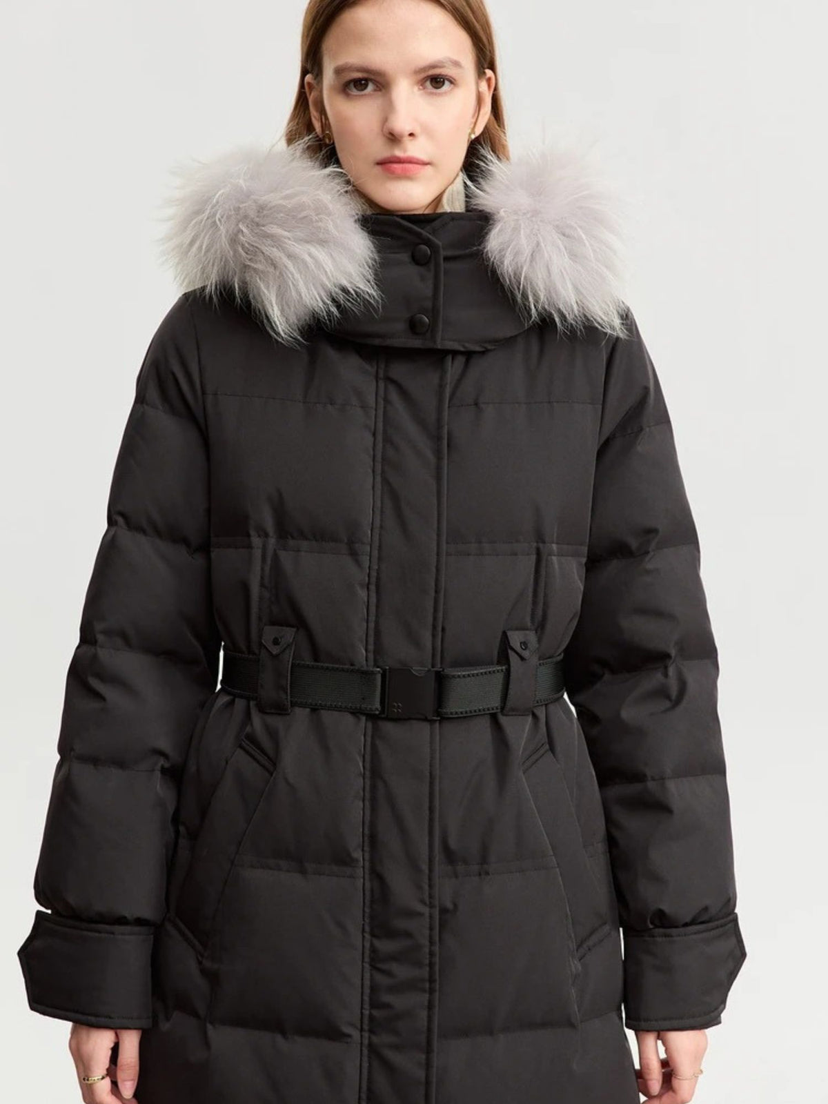 Black belted puffer coat with fur-trimmed hood, worn by model facing forward