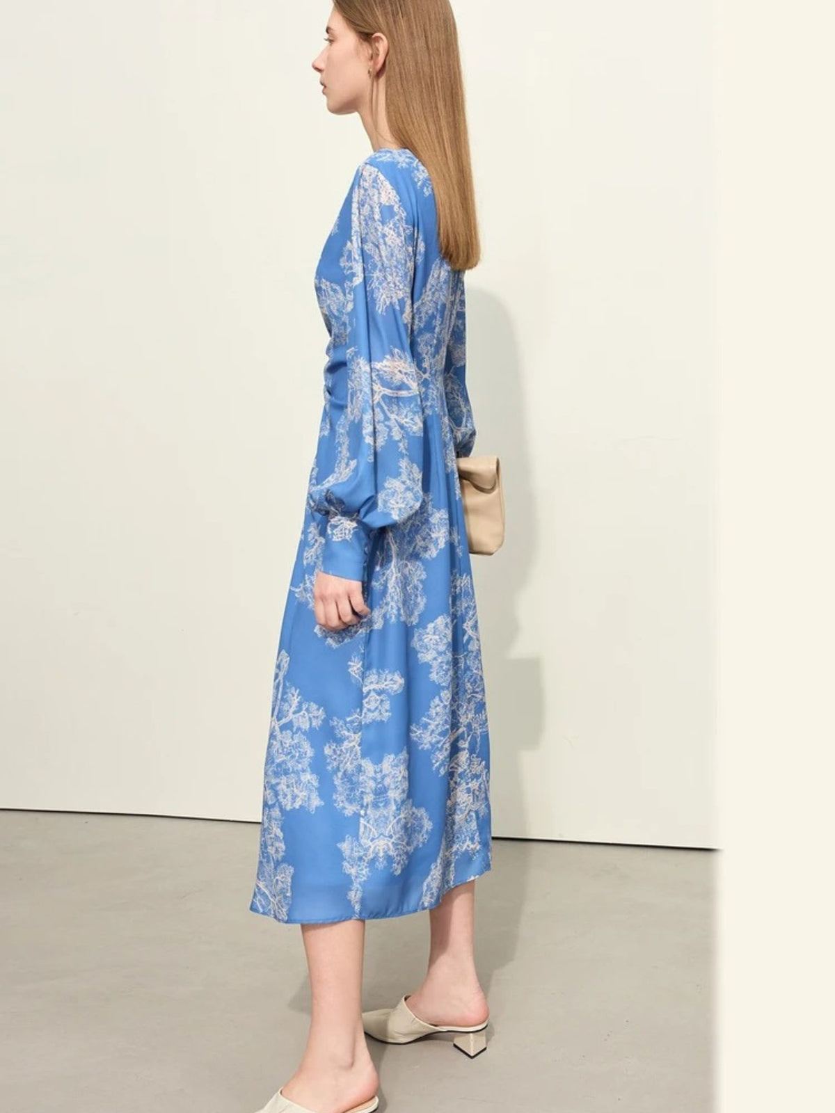 Side profile of blue printed dress with gathered waist and flared hem