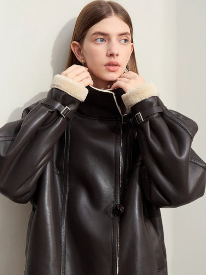 Model adjusting shearling collar of black faux leather aviator jacket