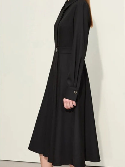 Angled back view of black buttoned dress with pleated skirt and midi length