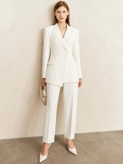 White tailored pantsuit with blazer and wide-leg trousers, styled with nude heels