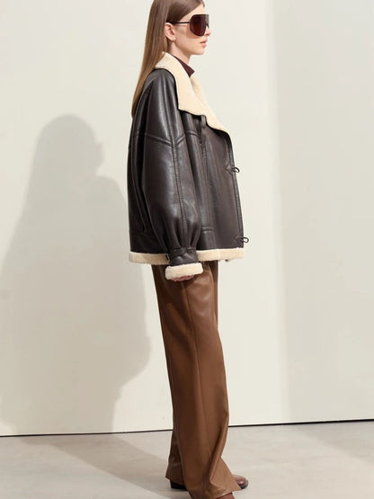 Model wearing aviator jacket and sunglasses, hands in pockets