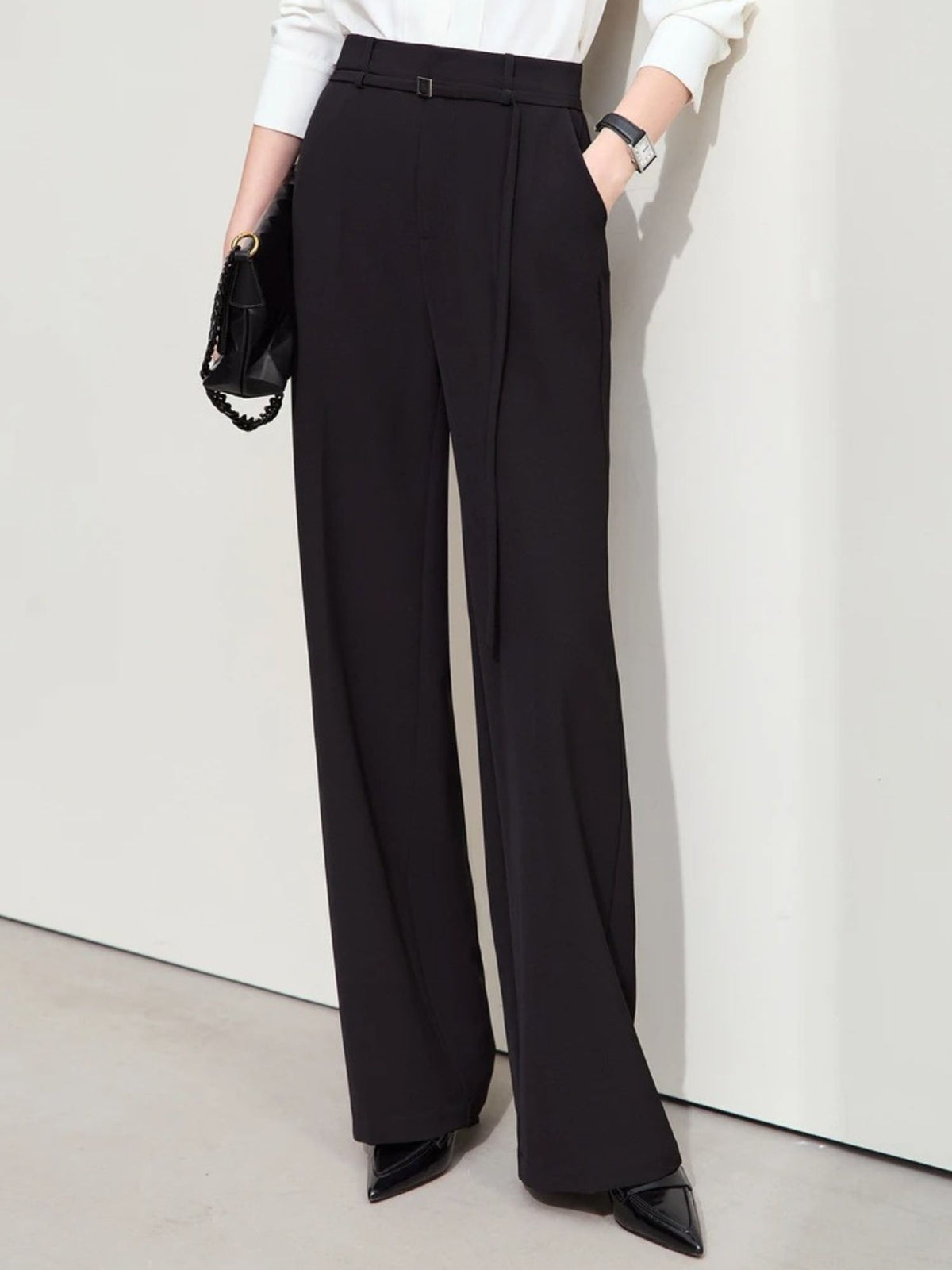 Close-up of black wide-leg trousers with high waist and clean front