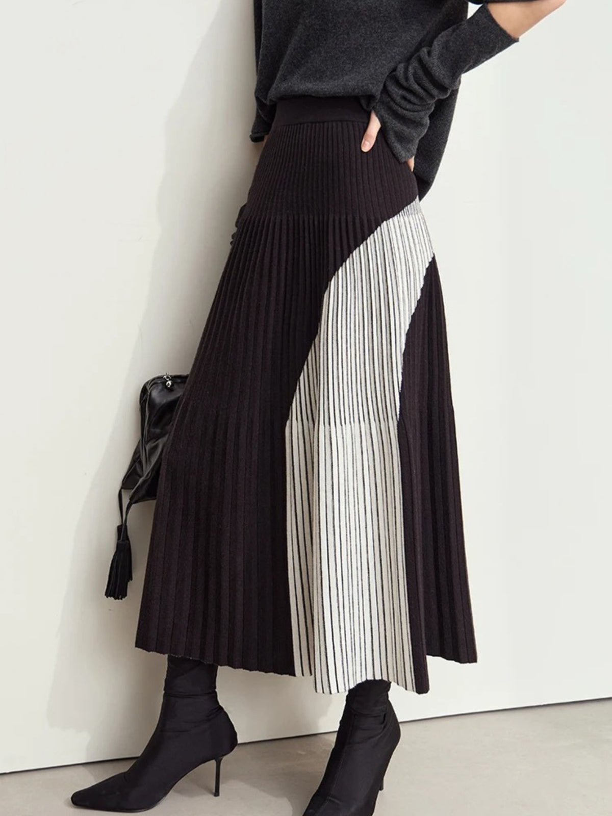 Back view of dark pleated colorblock skirt with high waist and flowy hem