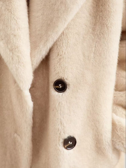 Close-up of a person wearing a beige coat with a neutral background