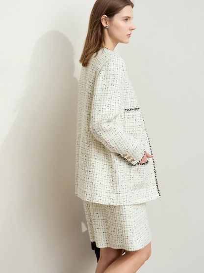 Ivory tweed jacket and skirt set styled with black boots and handbag